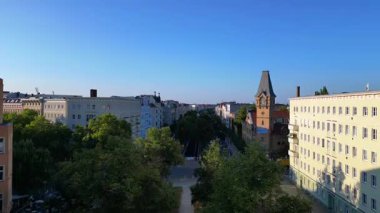 Berlin 'in yerleşim bölgesinden geçen sarı yükseltilmiş tren. İHA yükseliyor 