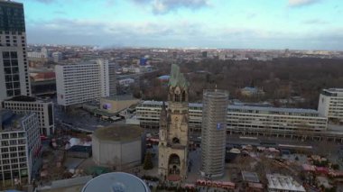 Almanya 'nın Berlin kentindeki Kaiser Wilhelm Memorial Kilisesi ile Breitscheidplatz' daki Noel pazarının hava görüntüsü. Sağ drona döndür 