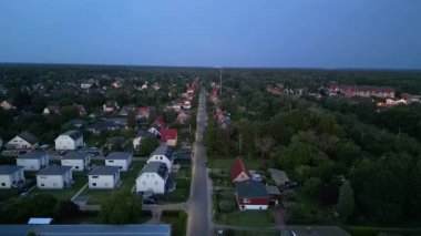 Brandenburg, Almanya 'da sakin bir akşam, çatıların, yemyeşil otlakların ve bir yol ağının sergilendiği bir yerleşim alanına iniyor. İHA alçalıyor 
