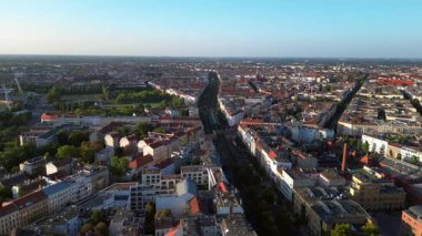 Berlin 'deki bir yerleşim bölgesinden geçen yükseltilmiş tren, şehrin taşıma sistemini gösteriyor. geniş yörünge görünümü dronu 