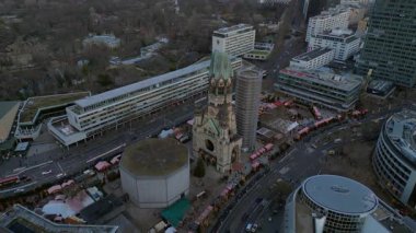 Kaiser Wilhelm Memorial Kilisesi ve Berlin, Almanya 'da Noel pazarı bulutlu bir kış gününde. İHA kamerası aşağıya bakıyor 