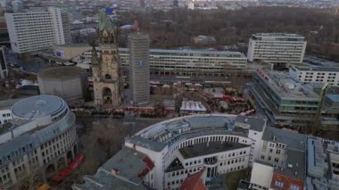 Almanya 'nın Berlin kentindeki Kaiser Wilhelm Memorial Kilisesi ile Breitscheidplatz' daki Noel pazarının hava görüntüsü. panorama yörünge dronu 