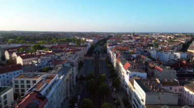 Berlin 'in yerleşim bölgesinden geçen sarı yükseltilmiş tren. Ters İHA uçuşu 