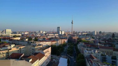 Berlin TV kulesi çatıların üstünde yükseliyor ve gün batımında Senefelderplatz 'da bir inşaat sahası var. panorama genel görünüm dronu 