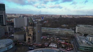 Almanya 'nın Berlin kentindeki Kaiser Wilhelm Memorial Kilisesi ile Breitscheidplatz' daki Noel pazarının hava görüntüsü. panorama genel görünüm dronu 