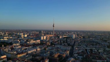 Berlin TV kulesi şehrin üzerinde dikiliyor, altın saatin sıcacık parıltısıyla yıkanıyor. panorama genel görünüm dronu 