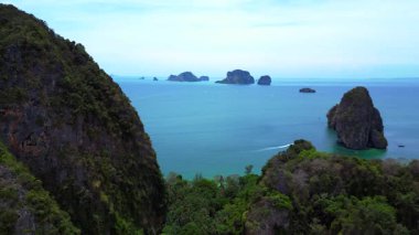 Tayland, Krabi 'deki verimli tropikal orman bitkisine bakan bir uçurumdan Railay sahilinin nefes kesici manzarası. statik üç ayaklı insansız hava aracı 