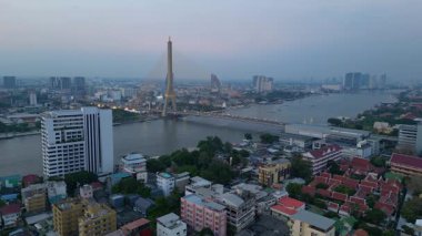 Rama VIII Köprüsü 'nün ve Chao Phraya Nehri' nin hava manzarası. Alacakaranlıkta Bangkok 'un aydınlatılmış şehir manzarası. panorama genel görünüm dronu 