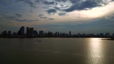 Kamboçya 'daki Phnom Penh ufuk çizgisi yakınlarındaki Mekong Nehri' nde kargo gemisi hareket ediyor. İHA alçalıyor 