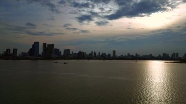 Kamboçya 'daki Phnom Penh ufuk çizgisi yakınlarındaki Mekong Nehri' nde kargo gemisi hareket ediyor. Yukarıdan insansız hava aracı görüntüleri 