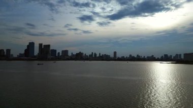 Kamboçya 'daki Phnom Penh ufuk çizgisi yakınlarındaki Mekong Nehri' nde kargo gemisi hareket ediyor. İHA yükseliyor 