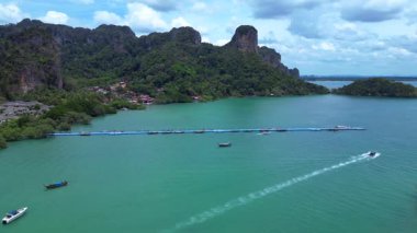 Tayland, Krabi 'deki verimli tropikal orman bitkisine bakan bir uçurumdan Railay sahilinin nefes kesici manzarası. panorama genel görünüm dronu 