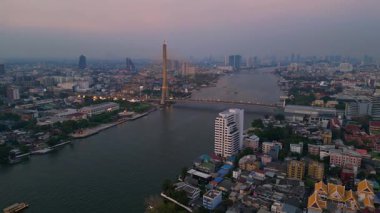 Rama VIII Köprüsü 'nün ve Chao Phraya Nehri' nin hava manzarası. Alacakaranlıkta Bangkok 'un aydınlatılmış şehir manzarası. geniş yörünge görünümü dronu 