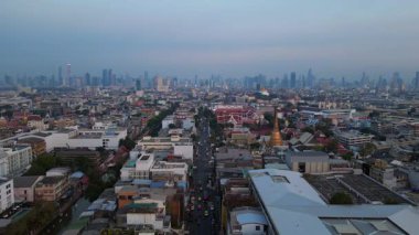 Geleneksel ve modern binaların arasında öne çıkan altın bir Chedi 'nin yer aldığı gün batımında Bangkok şehir manzarası. statik üç ayaklı insansız hava aracı 