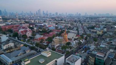 Geleneksel ve modern binaların arasında öne çıkan altın bir Chedi 'nin yer aldığı gün batımında Bangkok şehir manzarası. hız rampası hiper hareket zaman aşımı 