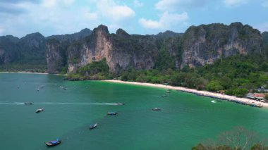 Railay Sahili 'nde ünlü kireçtaşı kayalıkları, yemyeşil alanları ve Andaman Denizi' nin canlı turkuaz suları sergileniyor. Ters İHA uçuşu 