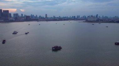 Rengarenk stilt evlerin ve Phnom Penh siluetinin havadan görünüşü akşamları Mekong Nehri 'ni yansıtıyor. hız rampası hiper hareket zaman aşımı 