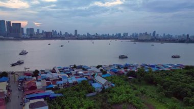 Rengarenk stilt evlerin ve Phnom Penh siluetinin havadan görünüşü akşamları Mekong Nehri 'ni yansıtıyor. hız rampası hiper hareket zaman aşımı 