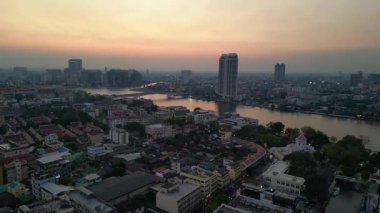 Bangkok üzerinde turuncu gün batımı çatıları ve binaları aydınlatıyor. statik üç ayaklı insansız hava aracı 