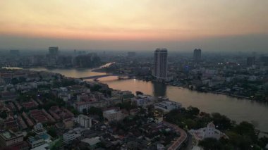 Bangkok üzerinde turuncu gün batımı çatıları ve binaları aydınlatıyor. panorama genel görünüm dronu 