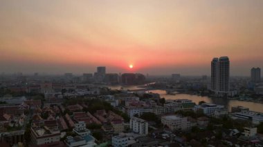 Bangkok üzerinde turuncu gün batımı çatıları ve binaları aydınlatıyor. panorama genel görünüm dronu 