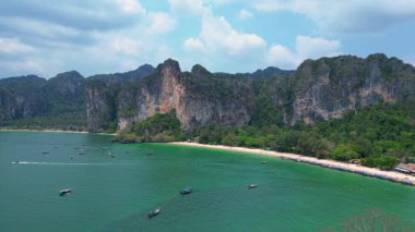 Railay Sahili 'nde ünlü kireçtaşı kayalıkları, yemyeşil alanları ve Andaman Denizi' nin canlı turkuaz suları sergileniyor. İticileri ileri çalıştır 