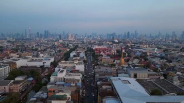 Geleneksel ve modern binaların arasında öne çıkan altın bir Chedi 'nin yer aldığı gün batımında Bangkok şehir manzarası. İticileri ileri çalıştır 