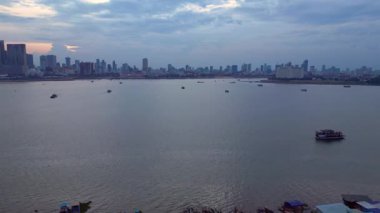 Rengarenk stilt evlerin ve Phnom Penh siluetinin havadan görünüşü akşamları Mekong Nehri 'ni yansıtıyor. Ters İHA uçuşu 