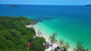 Kamboçya 'da tropik bir ada cenneti olan Koh Rong' un beyaz kumlu Kaoh Touch Sahili ve turkuaz sularının tadını çıkaran turistlerin hava manzarası. Yukarıdan insansız hava aracı görüntüleri 