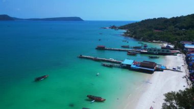 Kristal berrak turkuaz suları, beyaz kumlu plajı ve kıyı şeridi boyunca uzanan canlı bir balıkçı köyü olan Koh Rong adası. Yukarıdan insansız hava aracı görüntüleri 