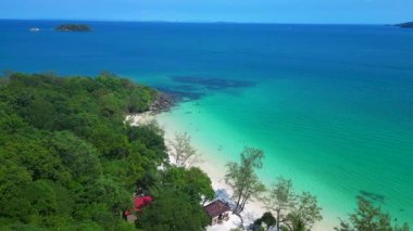 Kamboçya 'da tropik bir ada cenneti olan Koh Rong' un beyaz kumlu Kaoh Touch Sahili ve turkuaz sularının tadını çıkaran turistlerin hava manzarası. Yukarıdan insansız hava aracı görüntüleri 