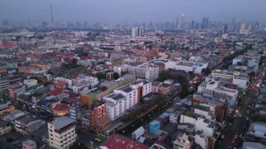 Geleneksel ve modern binaların arasında öne çıkan altın bir Chedi 'nin yer aldığı gün batımında Bangkok şehir manzarası. panorama genel görünüm dronu 