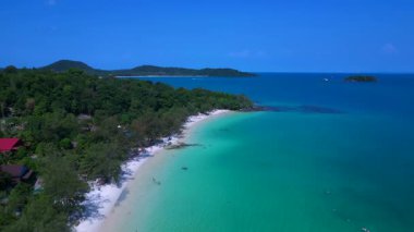Kamboçya 'da tropik bir ada cenneti olan Koh Rong' un beyaz kumlu Kaoh Touch Sahili ve turkuaz sularının tadını çıkaran turistlerin hava manzarası. İHA alçalıyor 