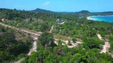 Kamboçya 'da tropik bir ada cenneti olan Koh Rong' un beyaz kumlu Kaoh Touch Sahili ve turkuaz sularının tadını çıkaran turistlerin hava manzarası. Sağ drona döndür 