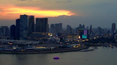 Phnom Penh 'in modern binaları, turuncu bulutlarla Mekong Nehri' nde günbatımını yansıtıyor. İHA yükseliyor 