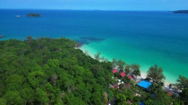 Kamboçya 'da tropik bir ada cenneti olan Koh Rong' un beyaz kumlu Kaoh Touch Sahili ve turkuaz sularının tadını çıkaran turistlerin hava manzarası. uçuş üstü insansız hava aracı 