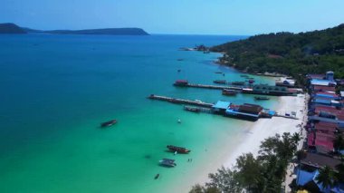 Kristal berrak turkuaz suları, beyaz kumlu plajı ve kıyı şeridi boyunca uzanan canlı bir balıkçı köyü olan Koh Rong adası. Ters İHA uçuşu 