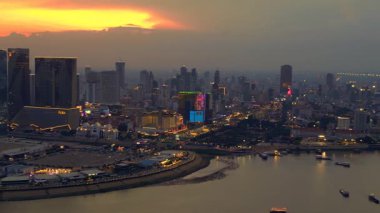 Phnom Penh 'in modern binaları, turuncu bulutlarla Mekong Nehri' nde günbatımını yansıtıyor. panorama genel görünüm dronu 