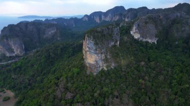 Tayland 'ın Krabi kentindeki tropikal ormandan yükselen yüksek kireçtaşı kayalıklarının havadan görünüşü. hız rampası hiper hareket zaman aşımı 