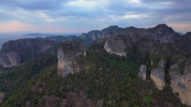 Tayland 'ın Krabi kentindeki tropikal ormandan yükselen yüksek kireçtaşı kayalıklarının havadan görünüşü. hız rampası hiper hareket zaman aşımı 