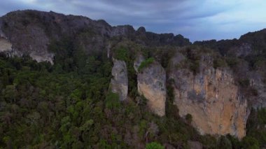 Tayland 'ın Krabi kentindeki tropikal ormandan yükselen yüksek kireçtaşı kayalıklarının havadan görünüşü. uçuş üstü insansız hava aracı 