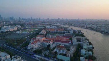 Puslu bir gündoğumunda çatıları ve gökdelenleri gösteren Bangkok kentsel hava manzarası. statik üç ayaklı insansız hava aracı 
