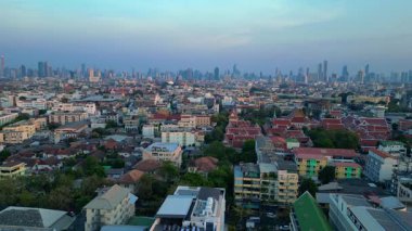 Puslu bir gündoğumunda çatıları ve gökdelenleri gösteren Bangkok kentsel hava manzarası. Yukarıdan insansız hava aracı görüntüleri 