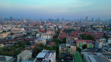 Puslu bir gündoğumunda çatıları ve gökdelenleri gösteren Bangkok kentsel hava manzarası. panorama genel görünüm dronu 