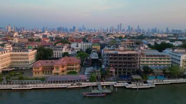 Puslu bir gündoğumunda çatıları ve gökdelenleri gösteren Bangkok kentsel hava manzarası. uçuş üstü insansız hava aracı 