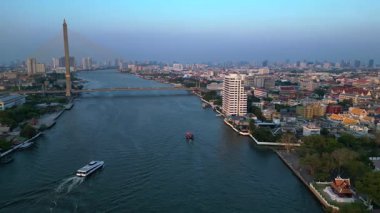 Gün batımında Chao Phraya Nehri 'nin Bangkok, Tayland' dan geçen havadan görüntüsü. Ters İHA uçuşu 
