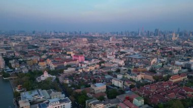 Puslu bir gündoğumunda çatıları ve gökdelenleri gösteren Bangkok kentsel hava manzarası. uçuş üstü insansız hava aracı 