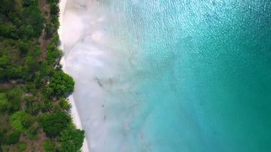 Kristal berrak turkuaz su, cennet koh chang thailand 'daki tropikal bitki örtüsünün yanında el değmemiş beyaz kumlu plajı nazikçe yıkıyor. dikey kuş bakışı dron 