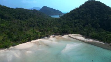 Long Beach 'in hava görüntüsü Tayland' ın Koh Chang kentindeki ormanlık tepenin yakınındaki gelgiti gösteriyor. panorama yörünge dronu 