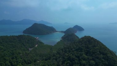 Turkuaz deniz ve mavi gökyüzüyle çevrili, yemyeşil çifte kumsal adalarının hava manzarası. Yukarıdan insansız hava aracı görüntüleri 